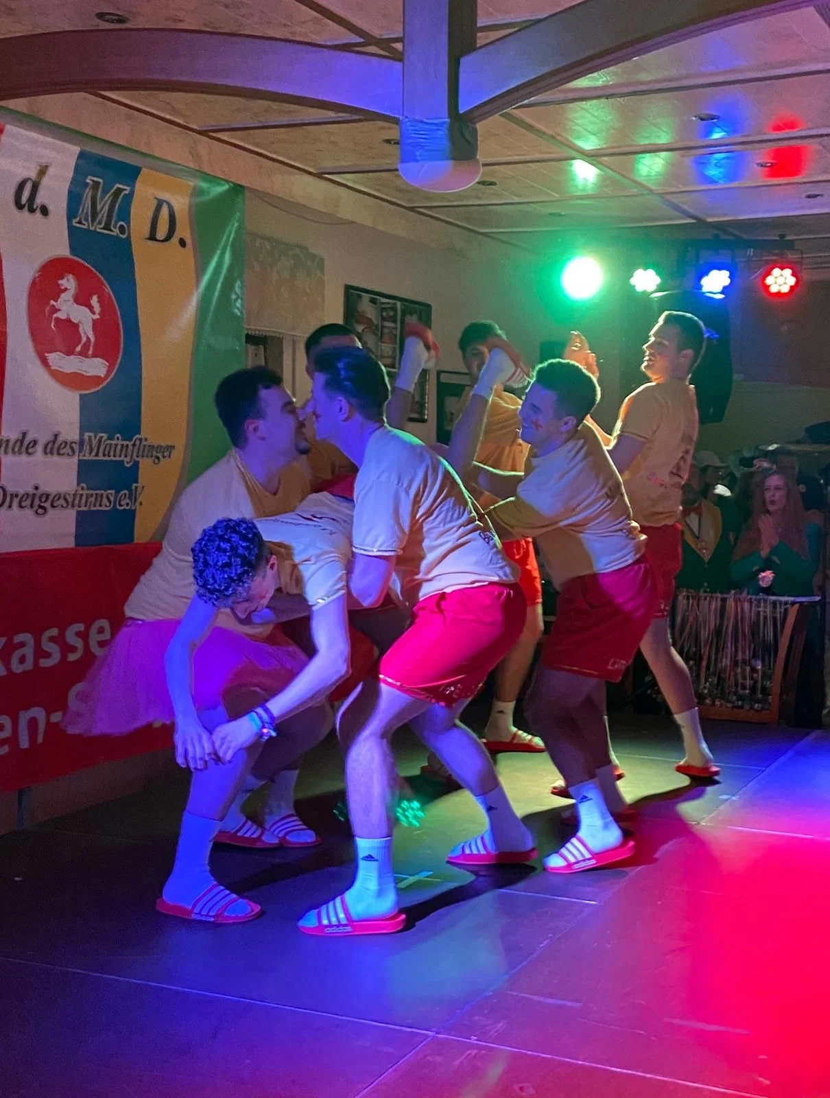 Die Gruppe tanzt in Baywatch-Kostümen in einer gemeinsamen Bühnenformation.