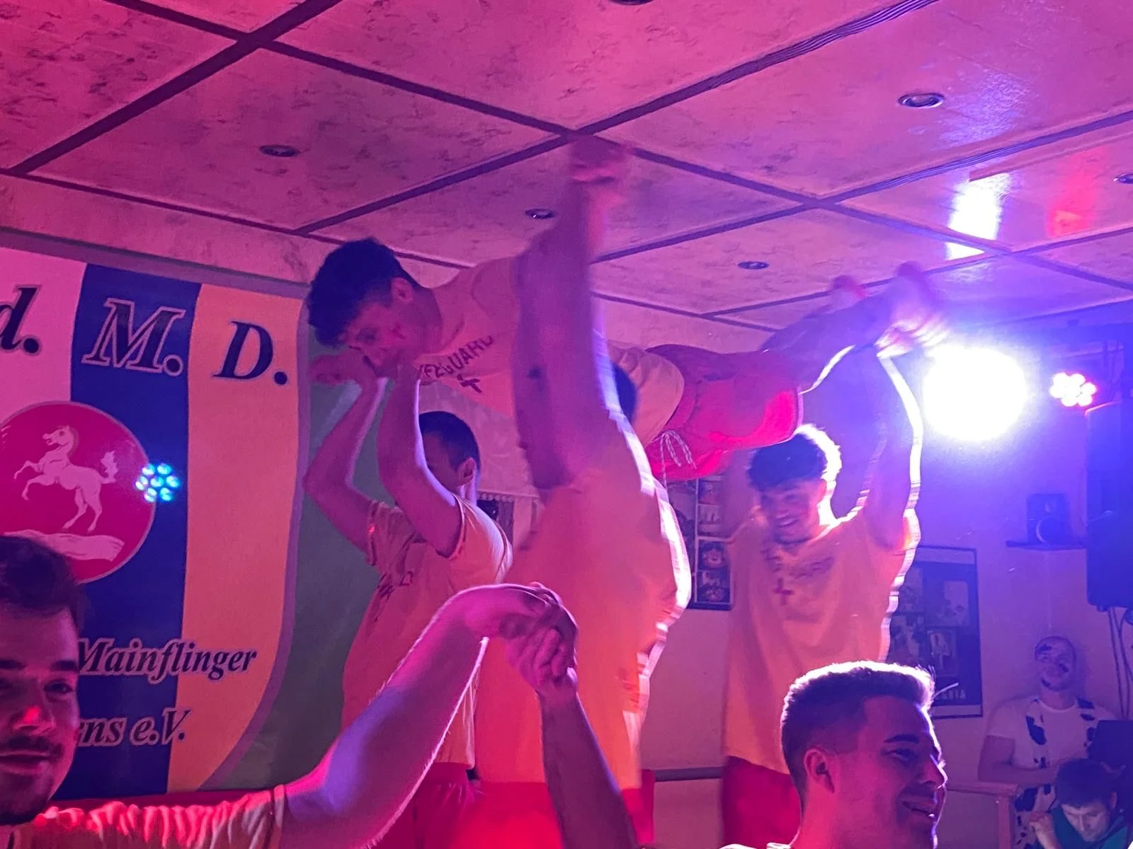 Die Baaschnicker heben beim Baywatch-Auftritt die Arme ins bunte Bühnenlicht.